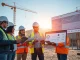 Construction team using AI compliance software on site with data center infrastructure in background