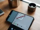 Smartphone displaying Instagram app with AI editing feature icon crossed out on a desk