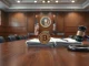 A Bitcoin coin and official documents on a council table in a New Hampshire government chamber, representing the rejected Bitcoin bond proposal.