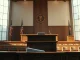 Interior of a courtroom with judge's bench and witness stand, representing the OpenAI copyright trial.