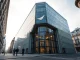Mistral AI headquarters in Paris, a modern glass building under an overcast sky.