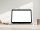 Laptop on a meeting room table displaying a meeting transcription app interface