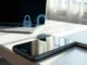 Smartphone and laptop on a desk with a digital padlock icon symbolizing AI data privacy concerns.