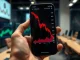 Smartphone showing a cryptocurrency price chart with a sharp decline, symbolizing the MANTRA token drop.