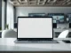 Laptop with an AI assistant interface on a desk in a modern office, symbolizing Microsoft's Copilot app consolidation.