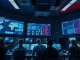 Cybersecurity analysts monitoring network activity in a modern operations center with blue and red lighting